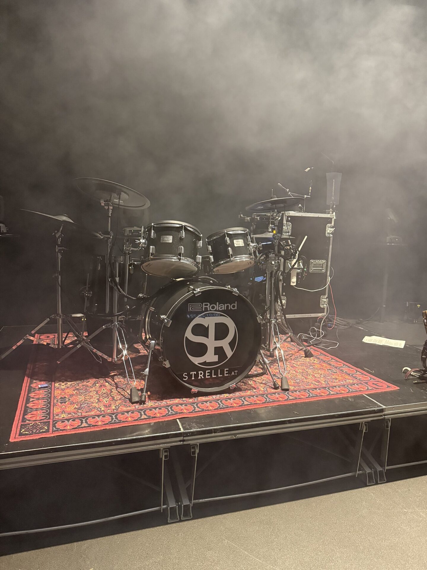 Aufgebautes Drumkit mit Strelle-Logo im Haze – die Band-Seite einer Veranstaltung