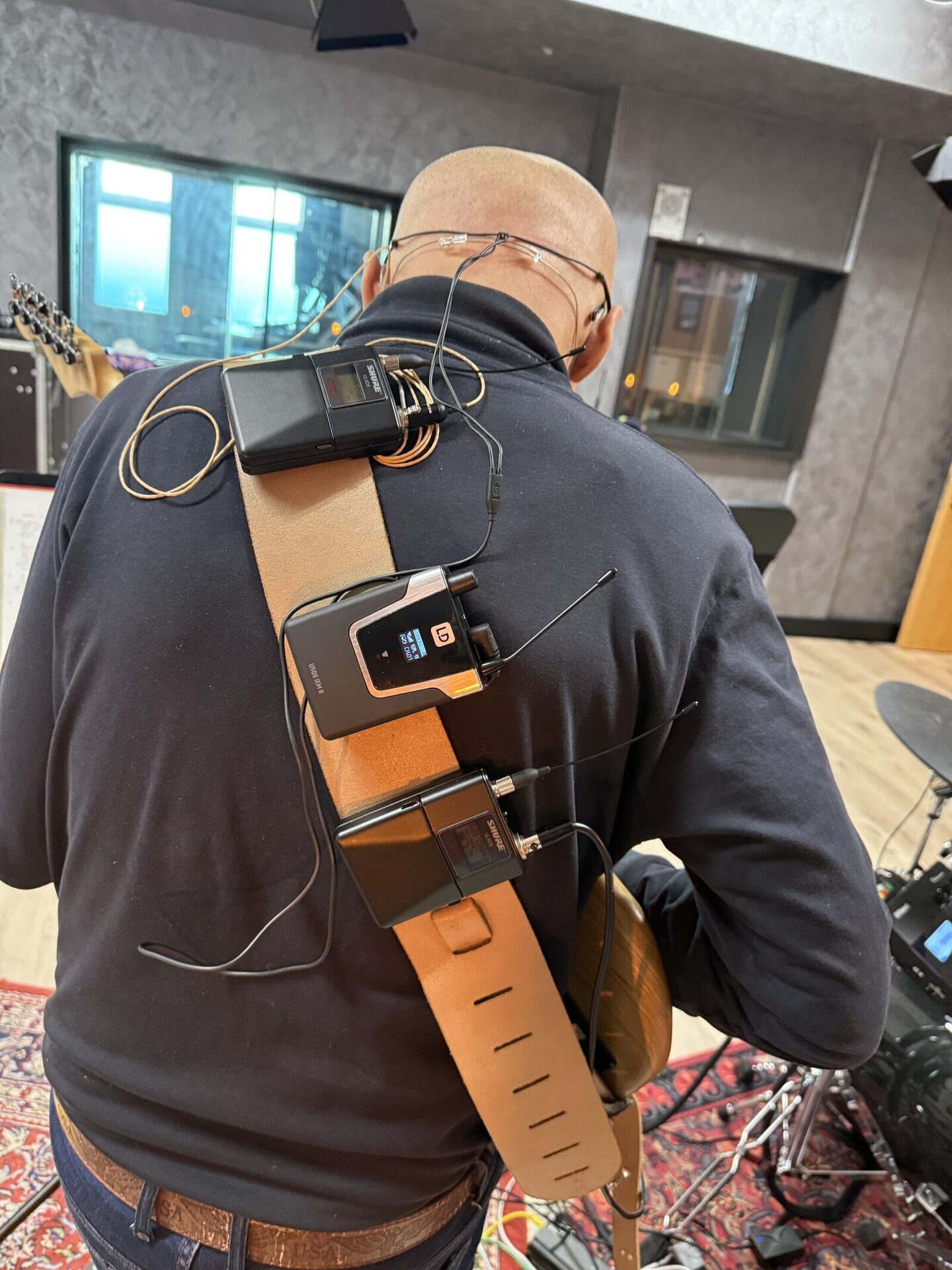 Mehrere Funkstrecken-Bodypacks am Gurt eines Gitarristen – Instrument, In-Ear und Sender laufen komplett kabellos