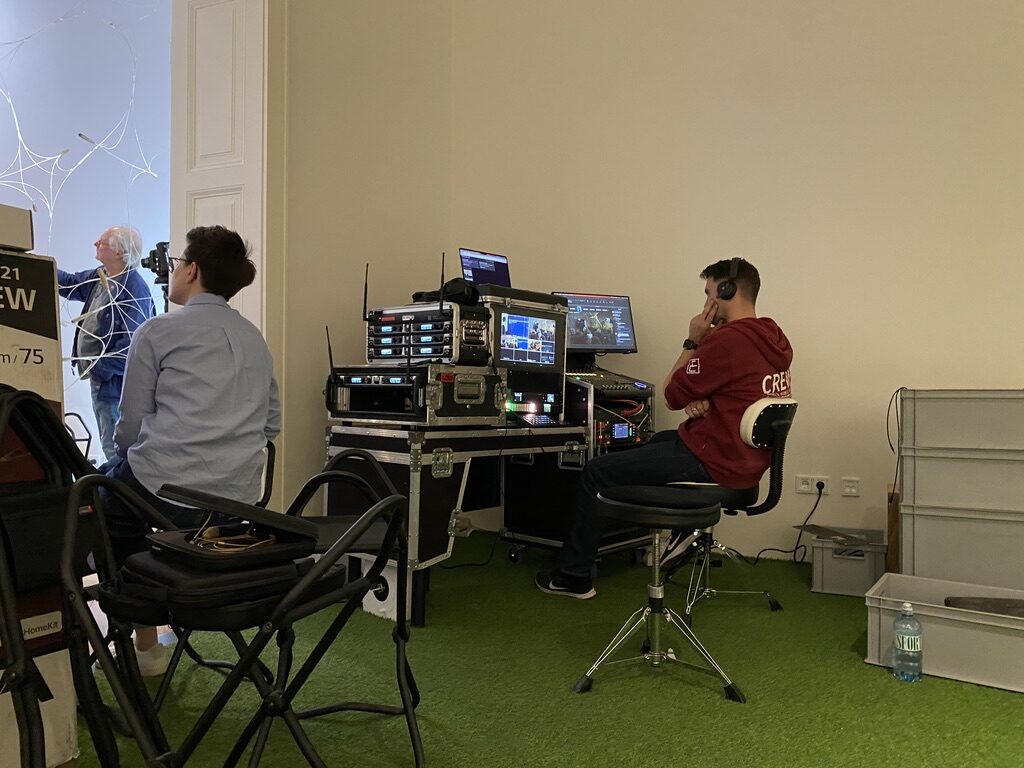 Mobiler Schnittplatz im Flightcase: Bildmischer, Funkstrecken und Multiview-Monitor, ein Operator mit Kopfhörer überwacht die Kamerabilder direkt vor Ort