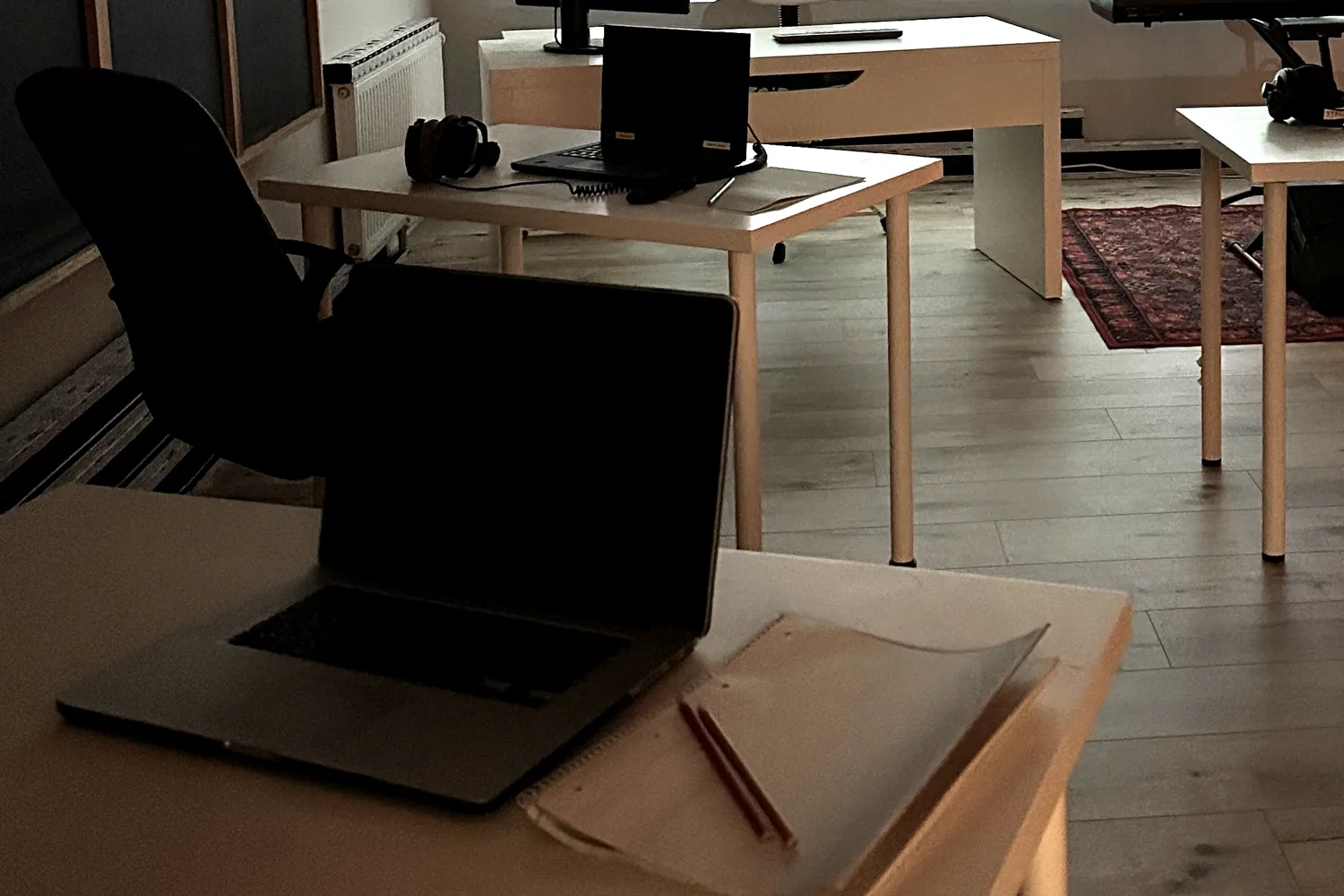 Kursraum im Studio: Einzeltische mit Laptop, Kopfhörern und Notizblock für Gruppenkurse