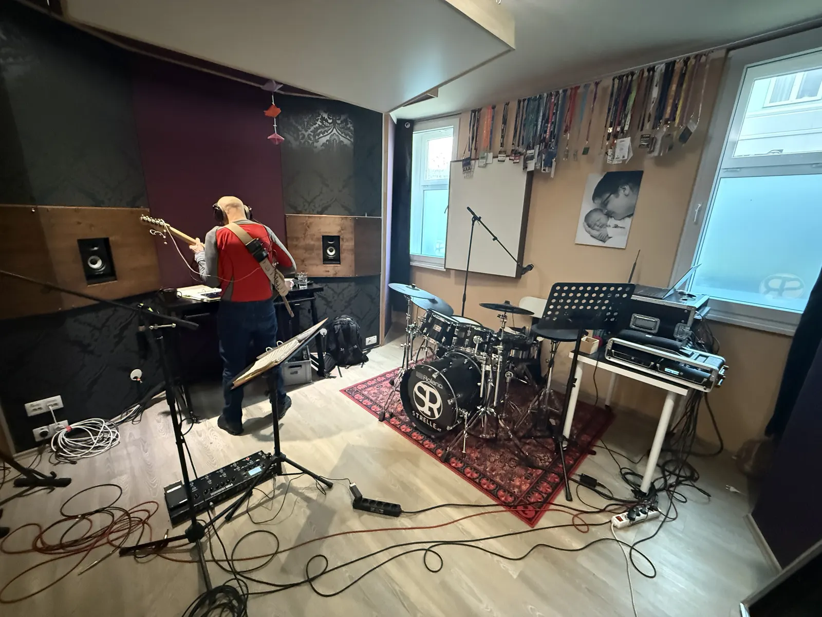 Gitarrenaufnahme mit Kopfhörer-Monitoring neben dem Schlagzeug-Setup