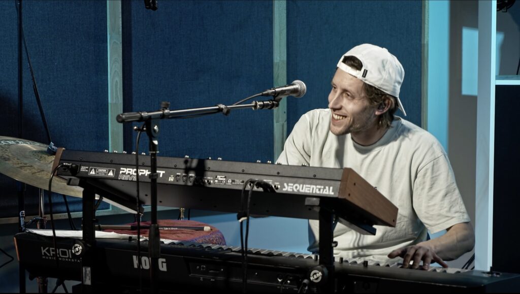 Mango Deluxe Live-Session im Strelle Studio – Keyboarder lächelt.